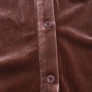 Detailed macro view of dark brown velvet fabric texture and four-hole resin buttons