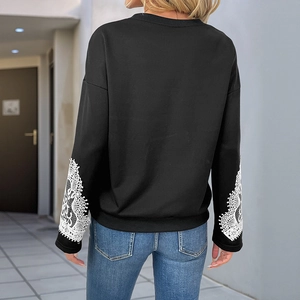 Women's black crewneck sweatshirt featuring elegant white lace patchwork on sleeves