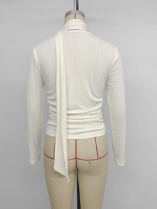 Detail view of the elegant ivory high-neck top featuring a long decorative back streamer