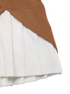 Close-up of contrast pleated hem detail on caramel knit sweater for a layered look