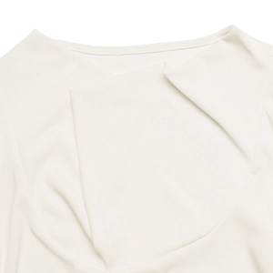 Detail view of the elegant draped cowl neckline on a white pleated long sleeve top
