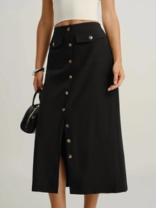 Close-up of high-waist black midi skirt with button details and flap pockets