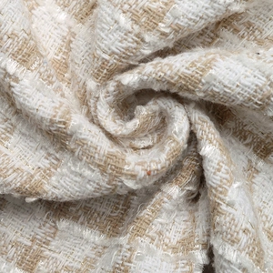 Detailed close-up of premium tweed fabric with woven golden metallic threads and texture