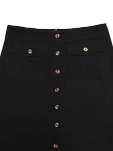 Detail view of high waist black midi skirt with amber buttons and flap pockets decoration