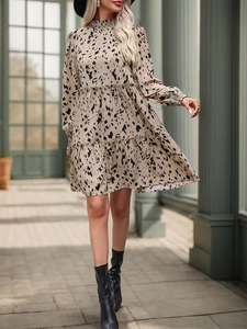 Detail of bohemian tiered mini dress with abstract print, high neck and ruffled sleeves