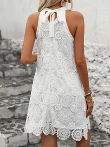Detailed back view of white sleeveless lace halter dress with backless bow tie design
