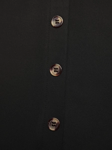 Detail view of brown amber buttons on black textured fabric with neat stitching