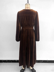 Detail view of the back of a brown velvet maxi dress with high waist and pleated texture