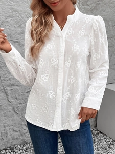 Vue détaillée du chemisier blanc à manches longues avec broderie florale et dentelle ajourée