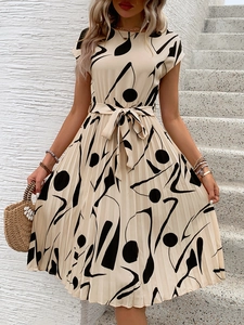 Détail d'une robe plissée à imprimé géométrique noir sur tissu beige avec ceinture nouée