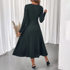 Elegant dark green ribbed long sleeve maxi dress with textured fabric and flared A-line silhouette