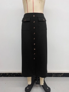 Detail of elegant black straight skirt featuring vintage buttons and functional flap pockets