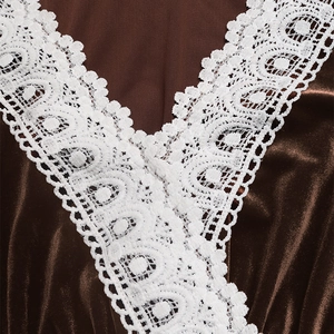 Detail of elegant V-neck with white crochet lace trim on dark brown velvet dress
