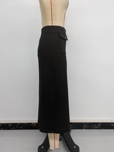 Detail view of the elegant black midi skirt with side decorative brown buttons and slit