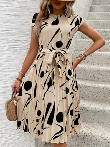 Détail d'une robe plissée avec imprimé géométrique abstrait et taille nouée crème