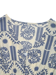 Détail du col en V avec imprimé ethnique et bouton blanc sur une robe d'été légère