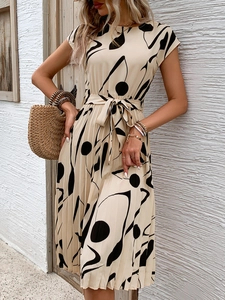 Détail d'une robe plissée beige avec motifs géométriques noirs et ceinture assortie d'été