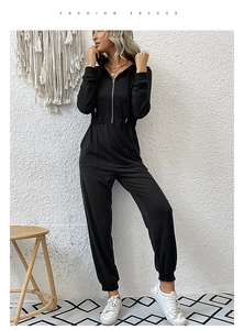 Détails de la combinaison noire à capuche avec plis à la taille et poignets élastiques