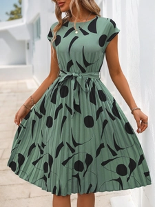 Détail de la robe plissée vert sauge avec imprimé géométrique noir et ceinture à nouer