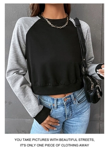 Modisches Cropped-Sweatshirt mit schwarz-grauen Raglanärmeln an einem weiblichen Model