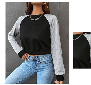 Detailansicht der Kontrast-Raglanärmel und des gerippten Ausschnitts am Crop-Sweatshirt