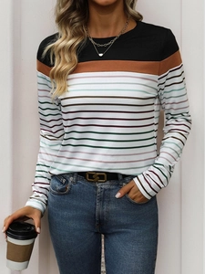 Detail view of round neck knit top with black, brown, and colorful striped patchwork