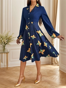 Detail eines dunkelblauen Hemdkleides mit gelben Blumenmustern und einer Knopfleiste