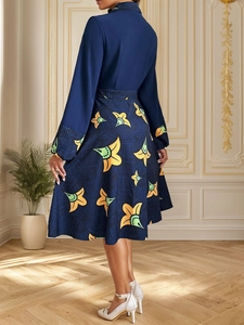 Detail eines eleganten dunkelblauen Langarmkleids mit floralem A-Linien-Rock im Design