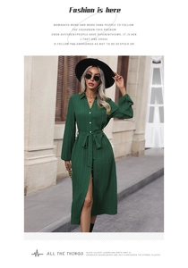 Detailed texture of dark green long sleeve pleated shirt dress with waist belt design