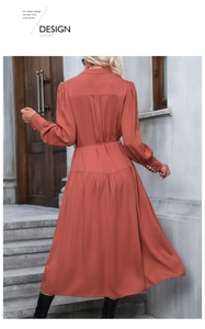 Detail of rust red long sleeve midi dress showing waist belt and row button cuffs