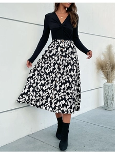 Détail du design à nœud en V et jupe boutonnée à motif noir et blanc sur la robe