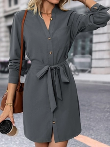 Détail de la robe chemise gris foncé avec ceinture à nouer et boutons sur le devant