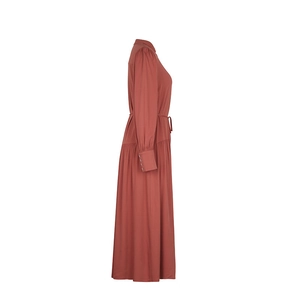 Detail view of brick red long sleeve dress with buttoned cuffs and drawstring waist tie