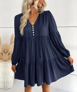 Detail of dark blue V-neck dress with white buttons and elegant lantern sleeves