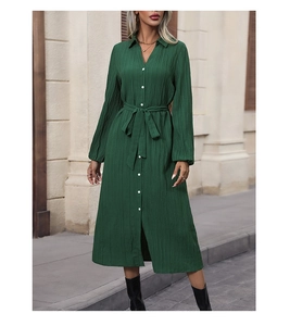 Detail of dark green pleated long-sleeve midi dress with waist belt and collar