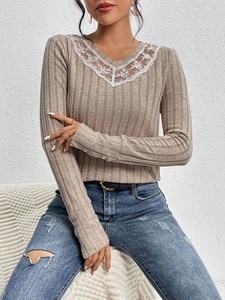 Close-up of khaki V-neck knit top featuring delicate white floral lace trim and ribbed texture