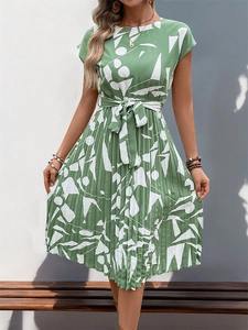Détail de la robe plissée verte avec motifs géométriques et ceinture assortie incluse