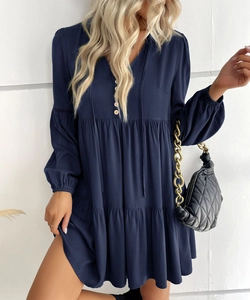 Detail view of navy blue tiered mini dress with decorative buttons and V-neckline