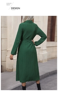 Back view detail of a dark green pleated shirt dress with long sleeves and a matching belt