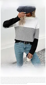 Detail of a women's knitted sweater featuring black and white striped color block design