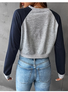 Detailansicht des kurzen zweifarbigen Sweatshirts mit Raglanärmeln und Rippenbündchen in Grau-Blau