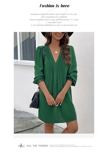Detailed view of the elegant deep V-neck and ruched texture on this green long sleeve dress