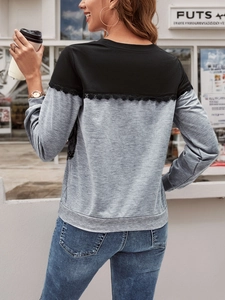 Detail view of the back showing black and grey contrast paneling with lace trim on a sweatshirt