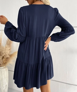 Detail of navy blue tiered short dress featuring lantern sleeves and pleated fabric