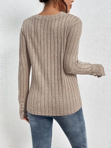 Detail showing the vertical ribbed texture and three-button cuffs on long sleeve knit top