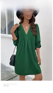 Detail of dark green V-neck long sleeve dress with elegant pleated neckline and elastic cuffs