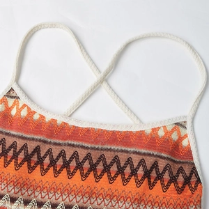 Close-up of knit dress featuring wave patterns in orange and brown with white straps