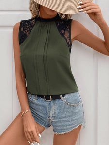 Detail of dark green sleeveless blouse featuring black lace shoulder and high neckline