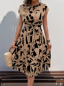 Détail d'une robe mi-longue plissée avec motifs abstraits noirs et ceinture nouée