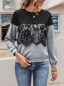 Detail of color-block sweatshirt featuring black floral lace overlay and ribbed cuffs